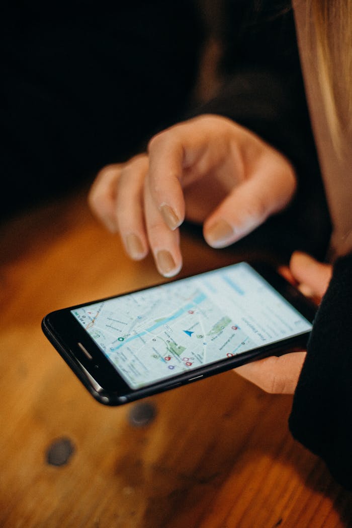 services-03 Close-up of a hand using a smartphone displaying a map for navigation.